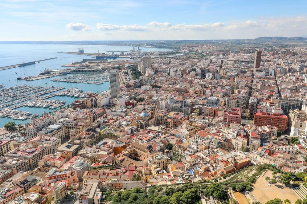 Vista aérea de Barcelona con el puerto y edificios residenciales, ideal para ilustrar los requisitos para alquilar un piso en Barcelona en 2025